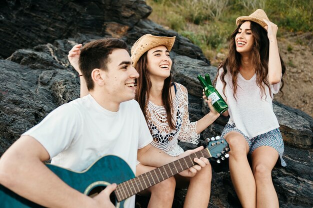 Three friends at the beach with guitar