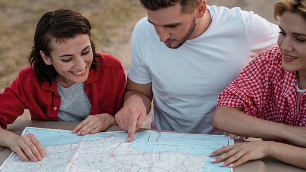 Tre amici che controllano insieme la mappa mentre viaggiano in macchina