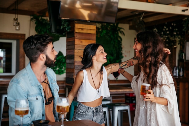 Three friends greeting each other in bar