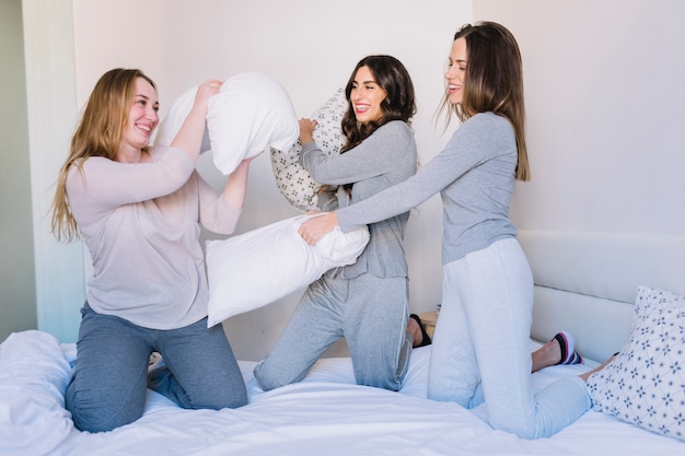 Three friends having pillow fight