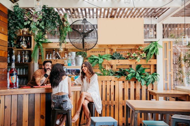 Three friends sitting at bar