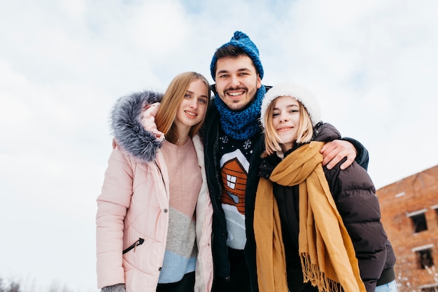 Three friends standing in winter clothes outside