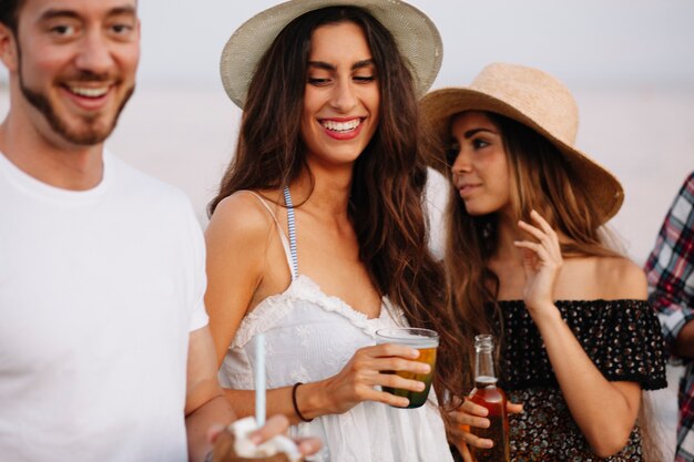 Three friends with drinks at a beach party