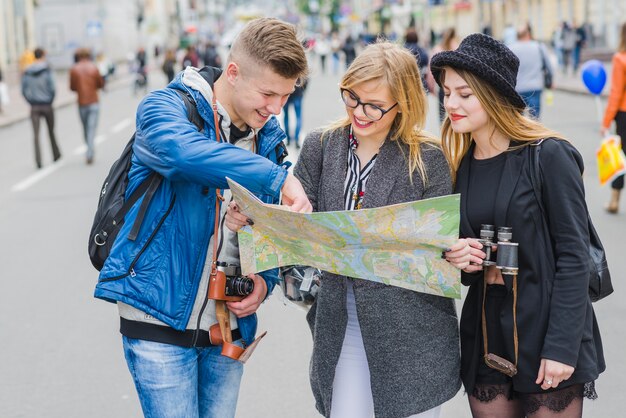 Three friends with map on street