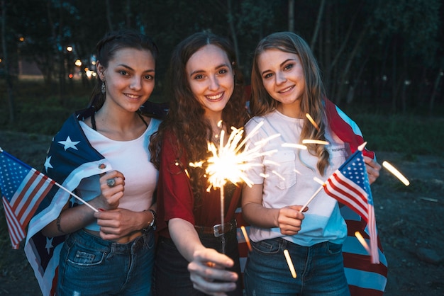 Foto gratuita tre ragazze che celebrano la festa dell'indipendenza con lo sparkler