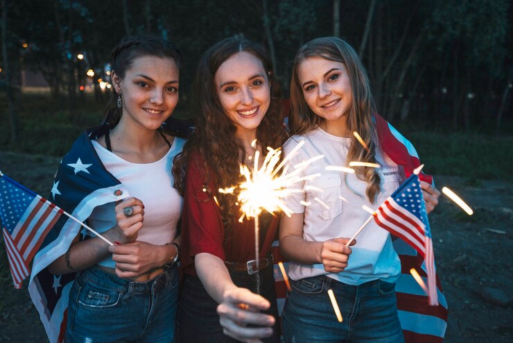 Free Photo three girls celebrating independence day with sparkler