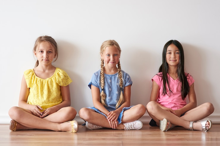 Free Photo three girls sitting with crossed legs