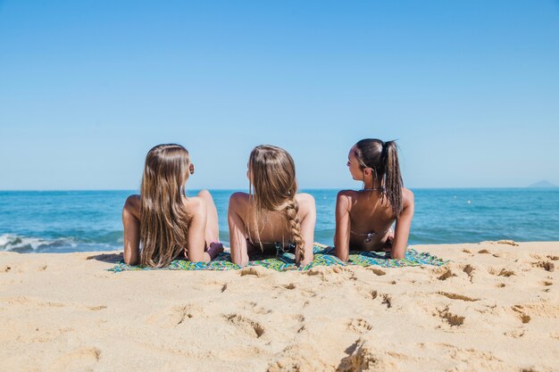 Три девушки, принимающие солнечную ванну