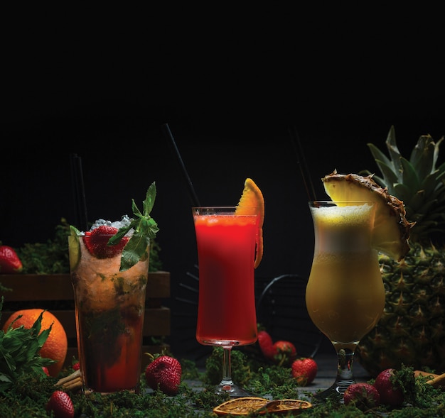 Free photo three glasses of tropical fruit cocktails