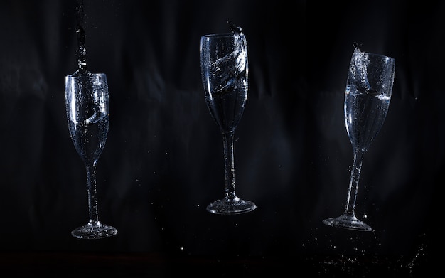 Three glasses of water on black background