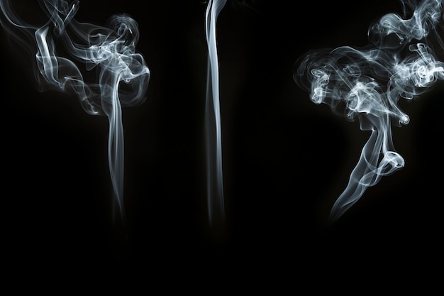 Three great silhouettes of smoke on black background