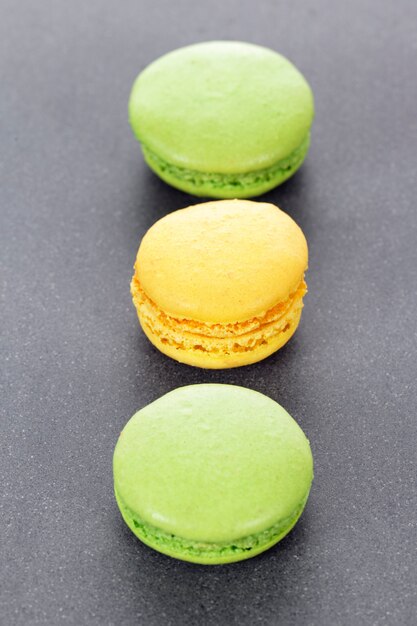 Three green and yellow macaroons in kitchen