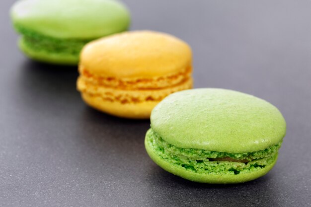 Three green and yellow macaroons in kitchen