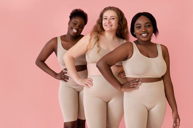 Three happy women posing while wearing a body shaper