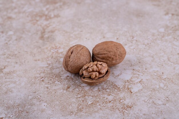 Three healthy delicious walnuts on marble background.