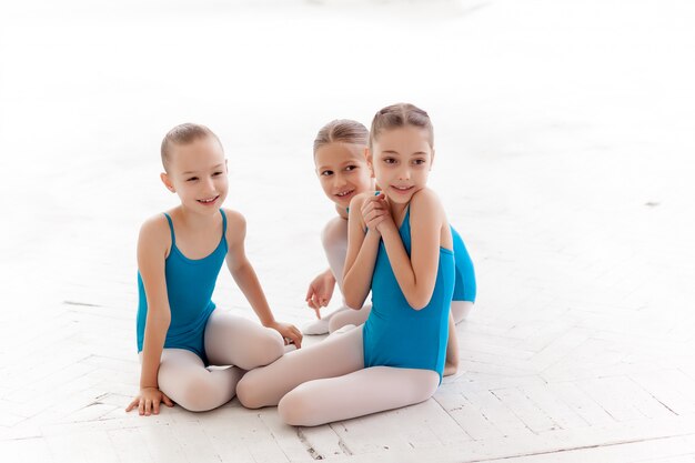 Three little ballet girls sitting and talking together