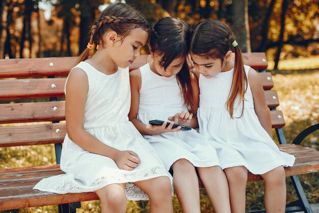 Three little sisters sitting in a summer park