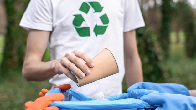 Three men collecting plastic garbage in a polluted park