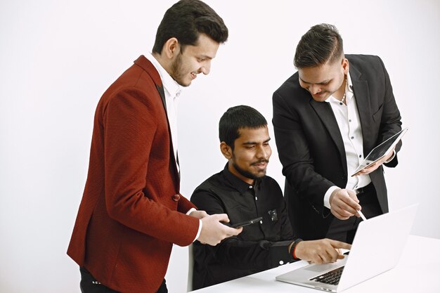Free photo three men discussing ideas. white wall. indian nationality.