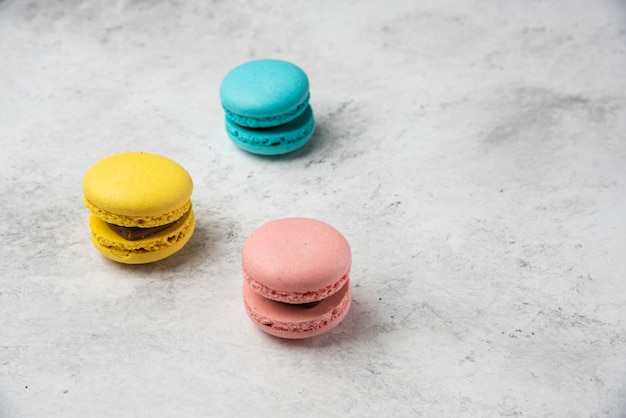 흰색 바탕에 세 가지 빛깔 된 macarons 디저트입니다.