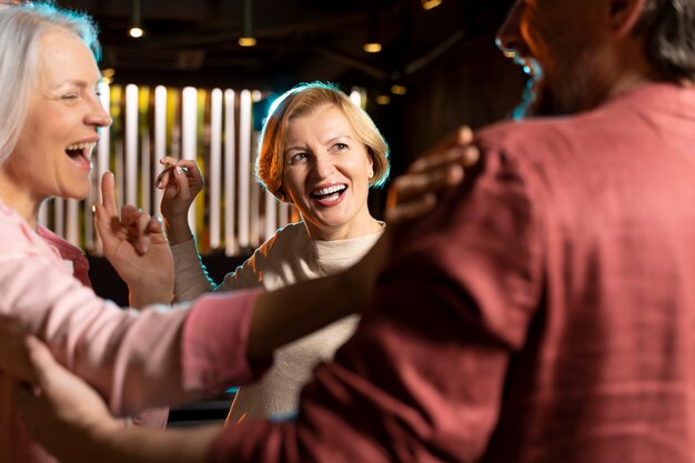 Three older friends laughing at a restaurant