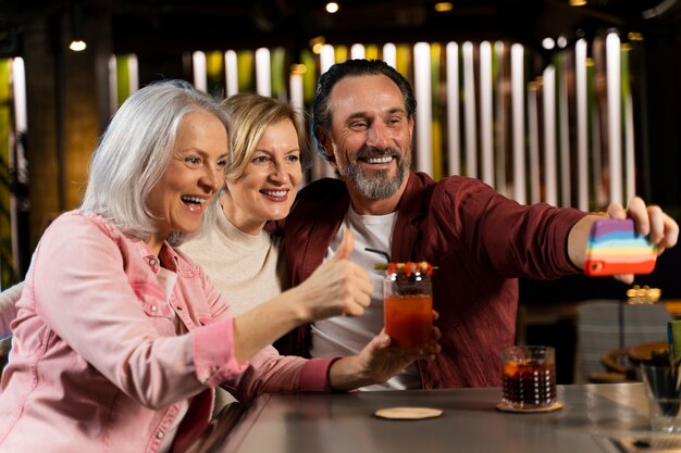 Three older friends taking a selfie at a restaurant