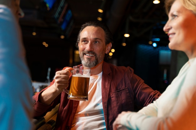 Three older friends talking and drinking at a restaurant