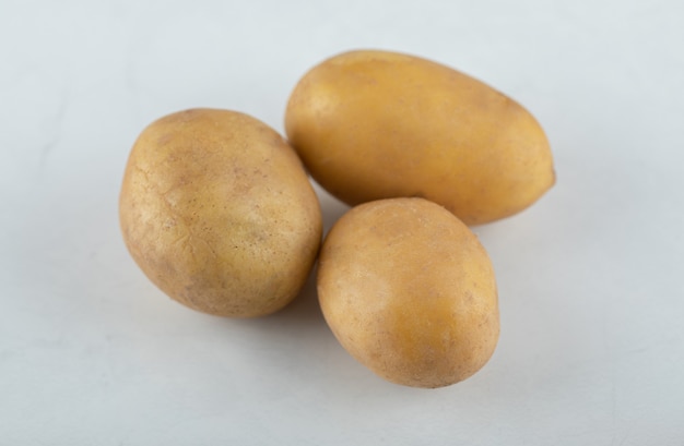 Three organic fresh potatoes. Close up photo .