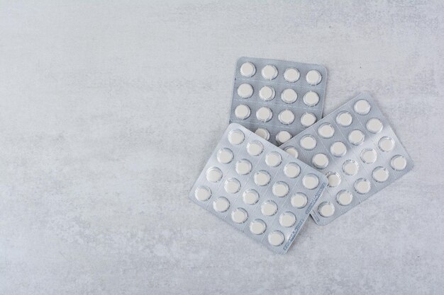 Three packs of medical drugs on marble surface. High quality photo