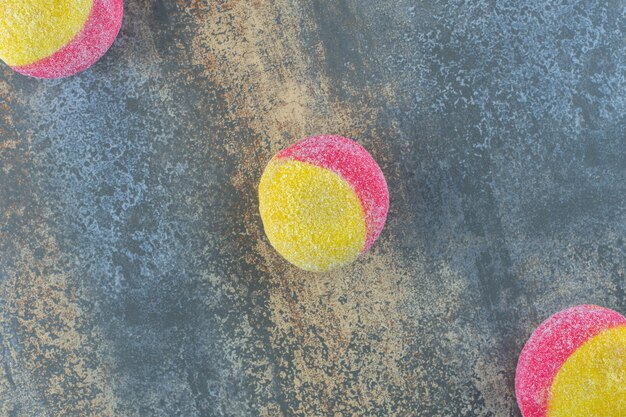 Three peach shaped cookies, on the marble background.