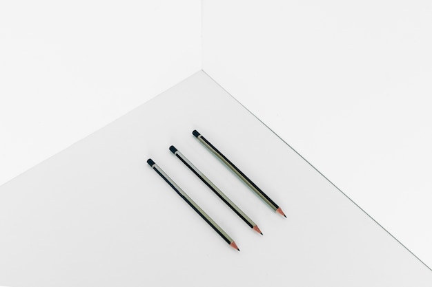 Free photo three pencils in corner of room