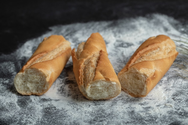 Three piece of fresh baguette on flour.