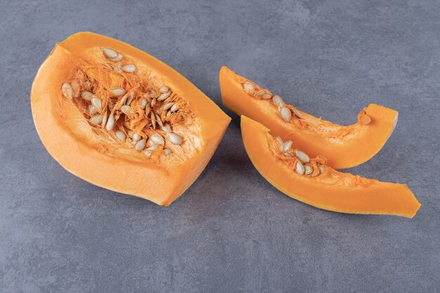 three pieces of pumpkin , on the marble surface.