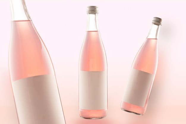 Три розовые бутылки макет-колы, вина или пива. пустые белые метки