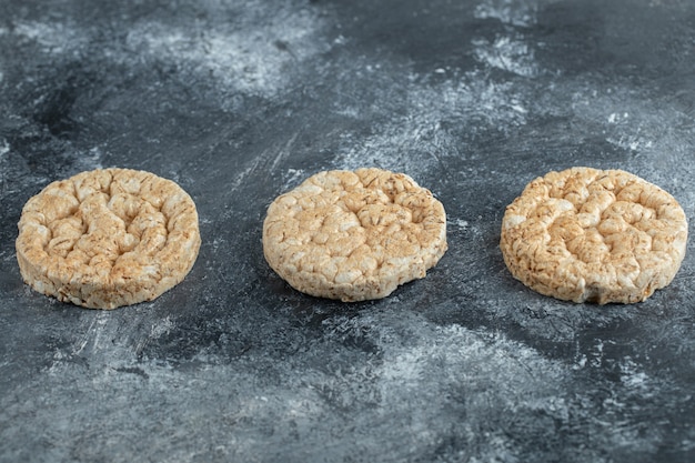 Three puffed rice cakes on marble surface