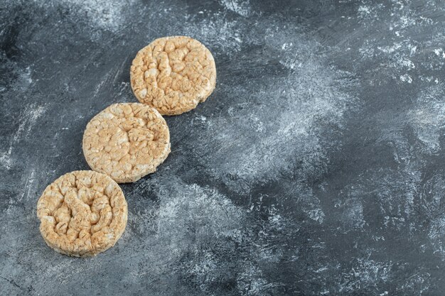 Three puffed rice cakes on marble surface