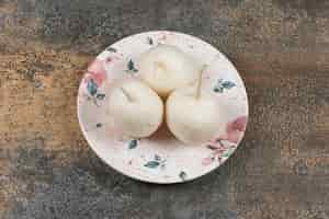 Free photo three radish on the plate , on the marble surface