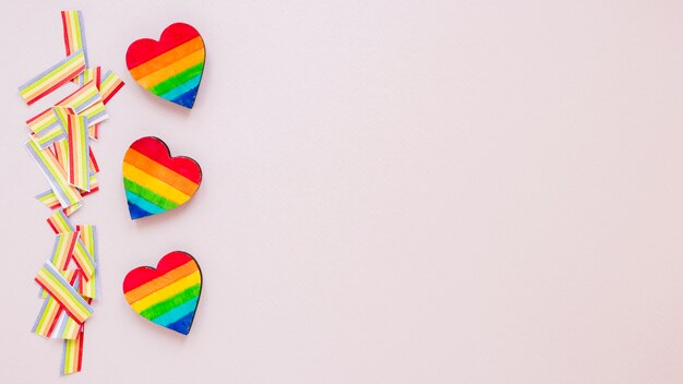 Free photo three rainbow hearts with paper rainbows on table