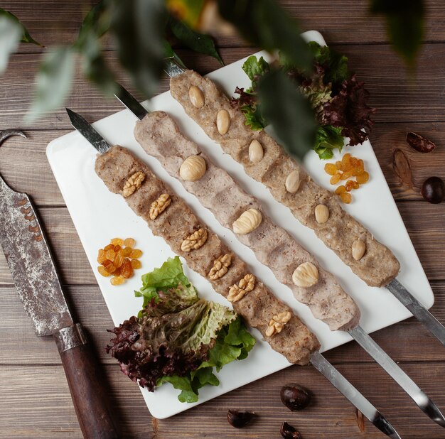 Free photo three skewers of mashed walnut, chesnut, almond mixture