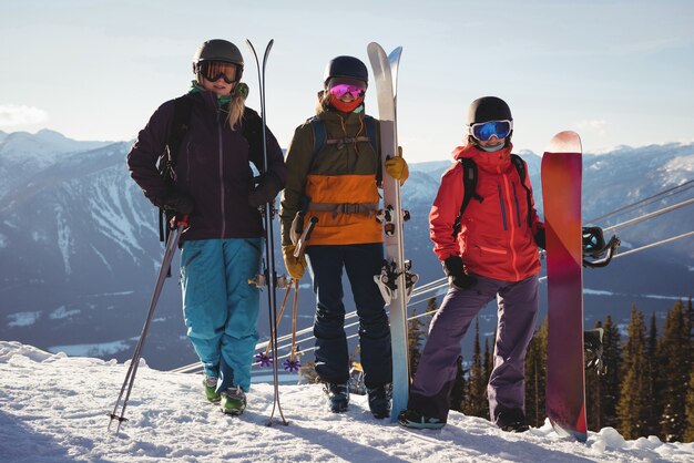 Three skiers with skies standing on snowy landscape