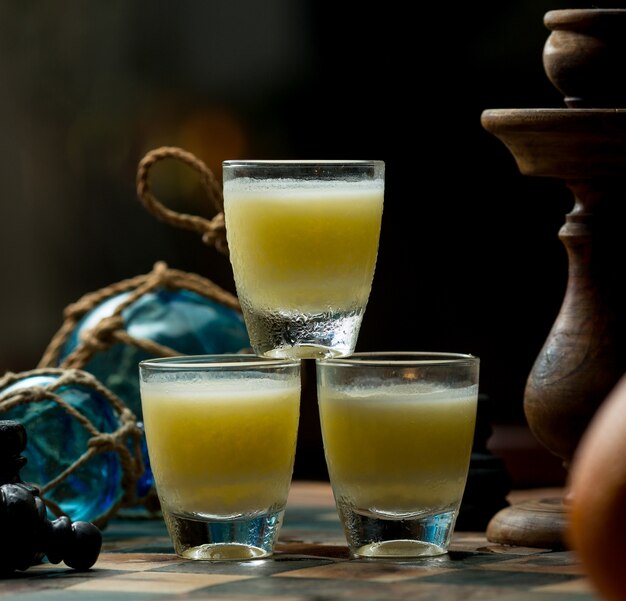 Three small glasses of alcohol drink standing in the bar table