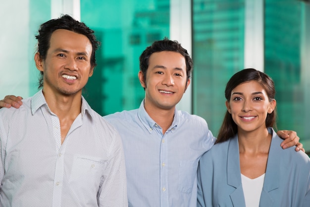 Three Smiling Friendly Business People Embracing