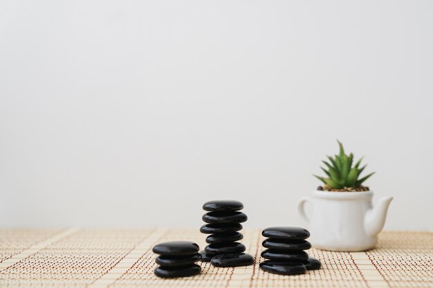 Three stacks of volcanic stones with pot of background