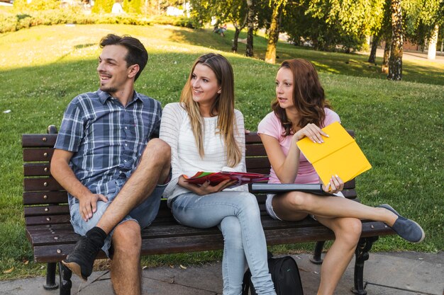 3人の学生がベンチ上にポーズを取る