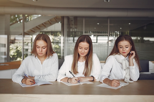 Tre studenti seduti al tavolo in una classe