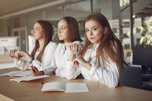 Three students sitting at the table in a class