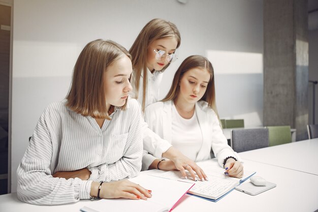 Three students sitting at the table in a class