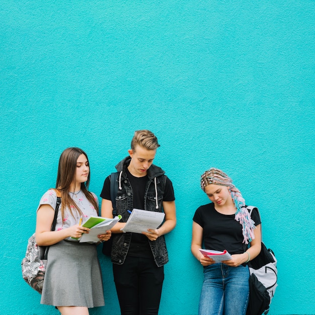 Foto gratuita tre studenti con libri su blu