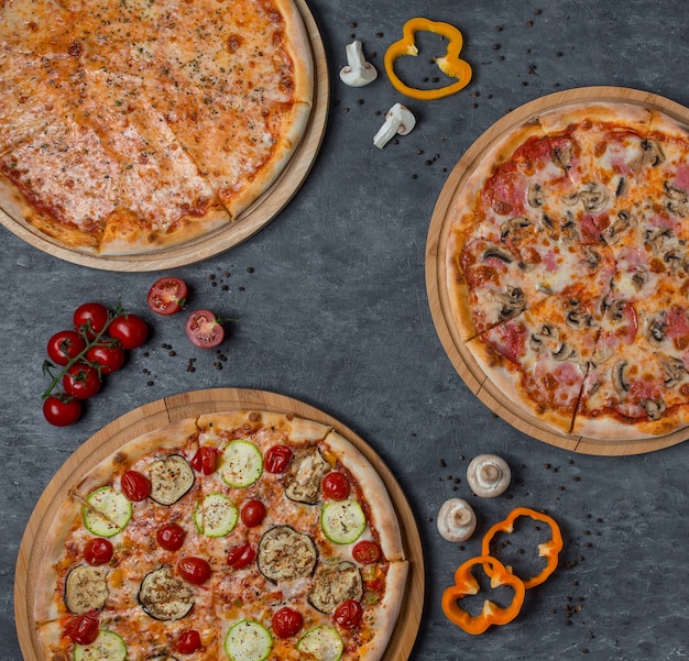 Free photo three types of pizza with mixed ingredients
