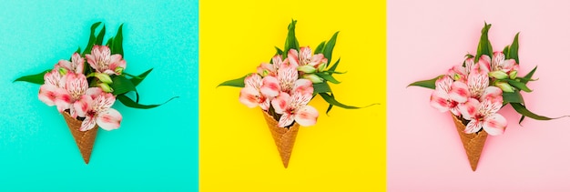 Three waffle cones with flowers on table